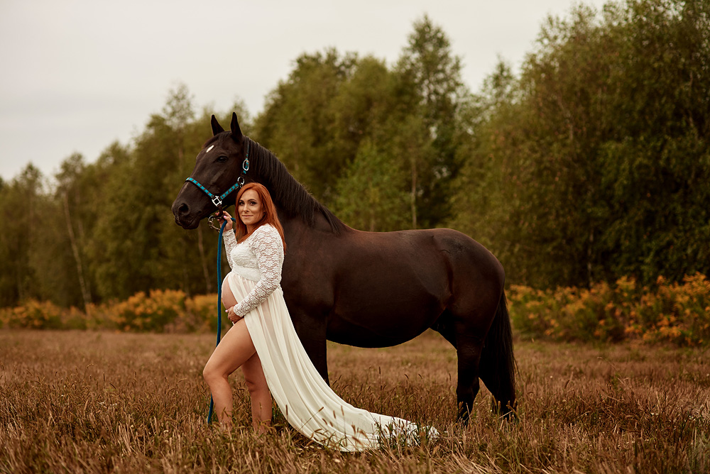 kobieca sesja zdjęciowa ciążowa wykonana przez fotografa fleszka studio karolina grzesiak w plenerze w okolicach Częstochowy z koniem w lesie