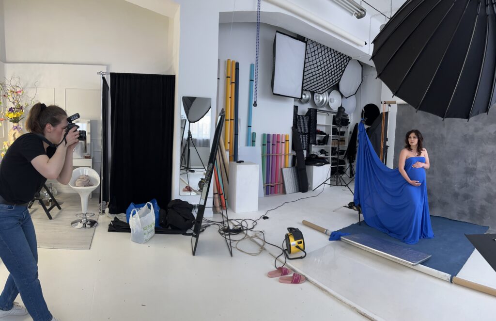 Fotograf wykonuje kobiecą sesję ciążowo w studio fotograficznym - za kulisami
